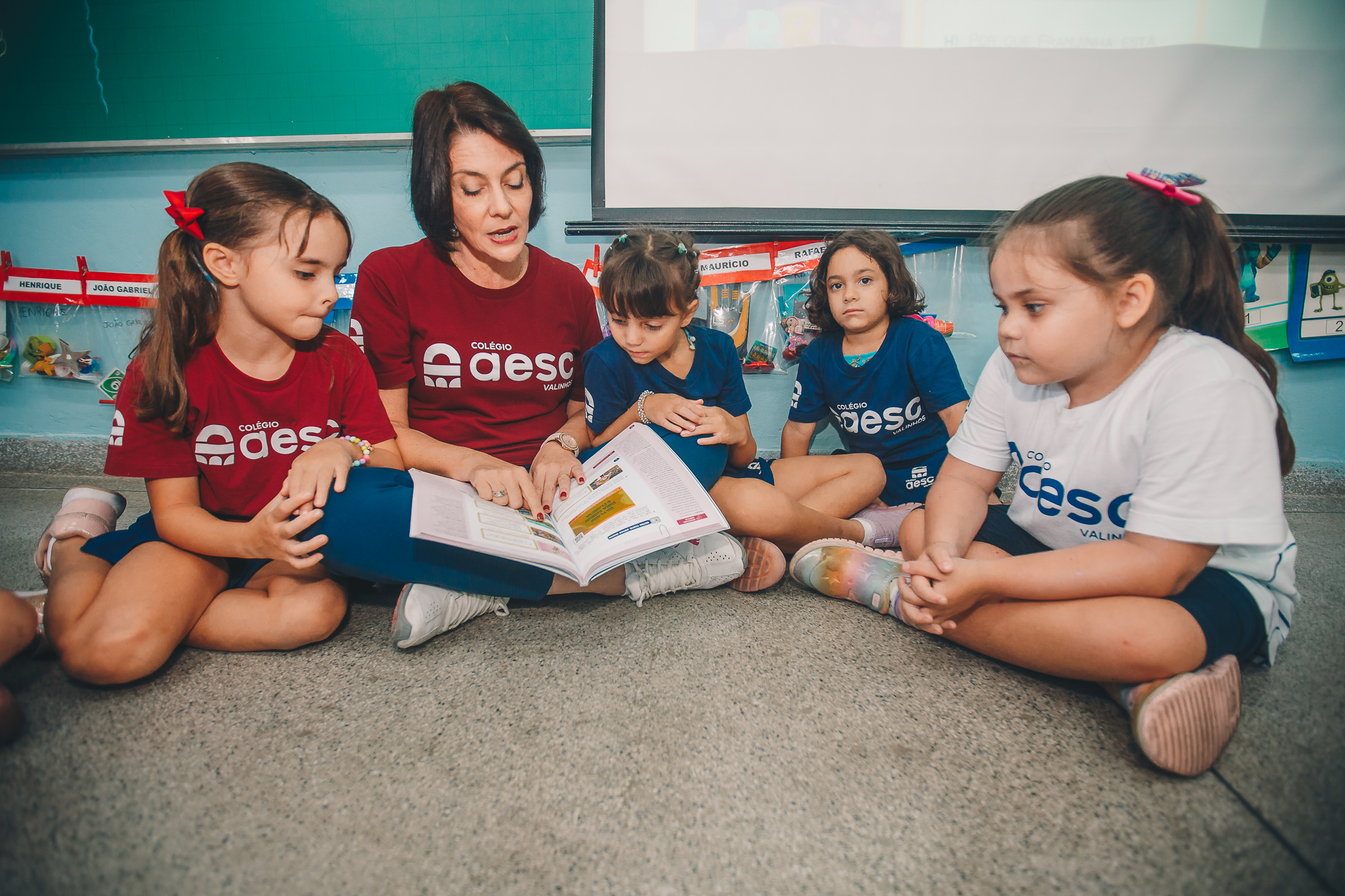 Professora lendo com alunos AESC